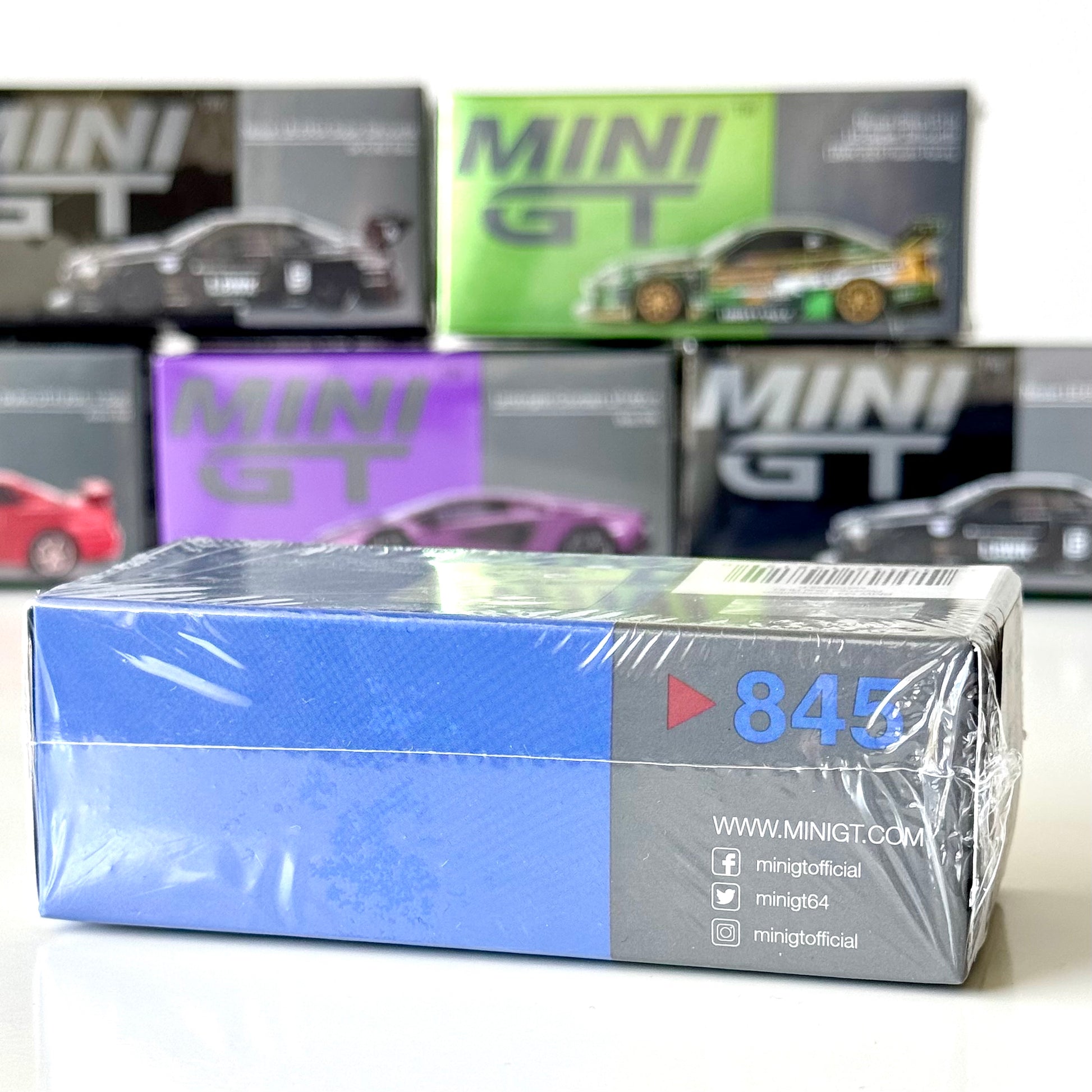 Side view of Mini GT packaging for BMW M4 Competition diecast in Portimao Blue