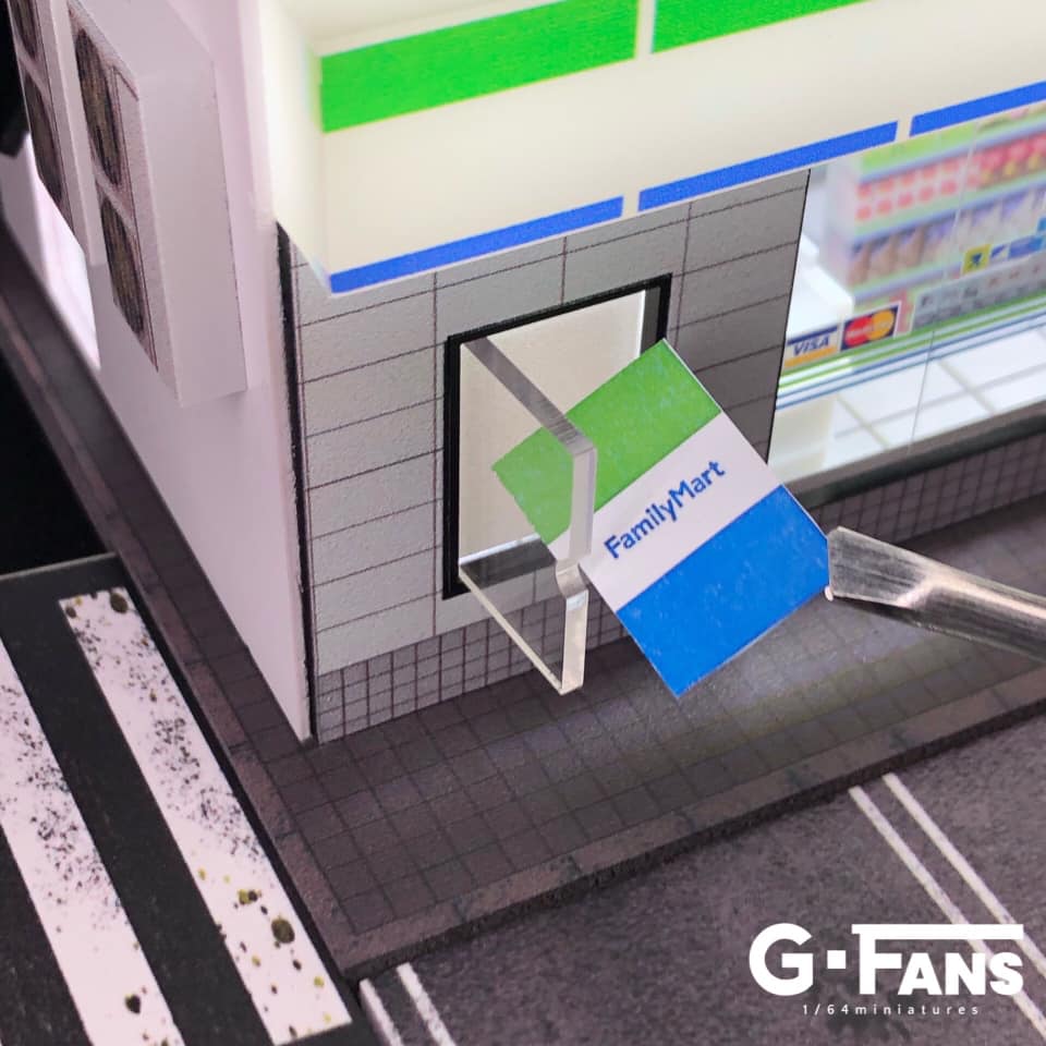 Close-up of Family Mart logo and signs on miniature diorama