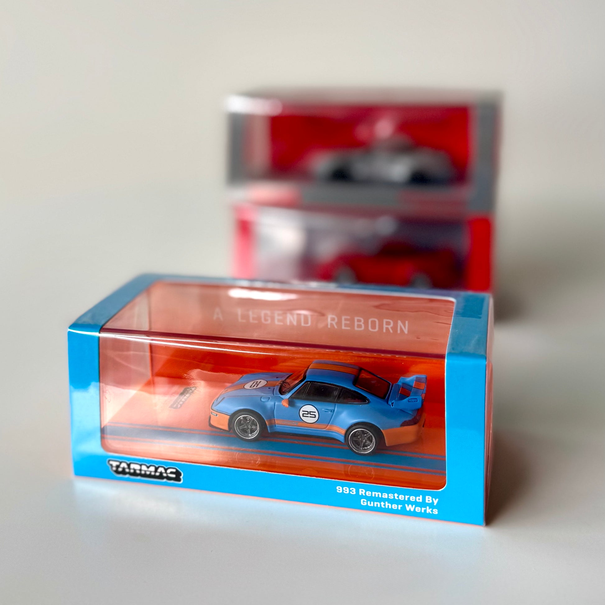 Porsche 993 Remastered by Gunther Werks Blue & Orange 1:64 diecast in display box – front view
