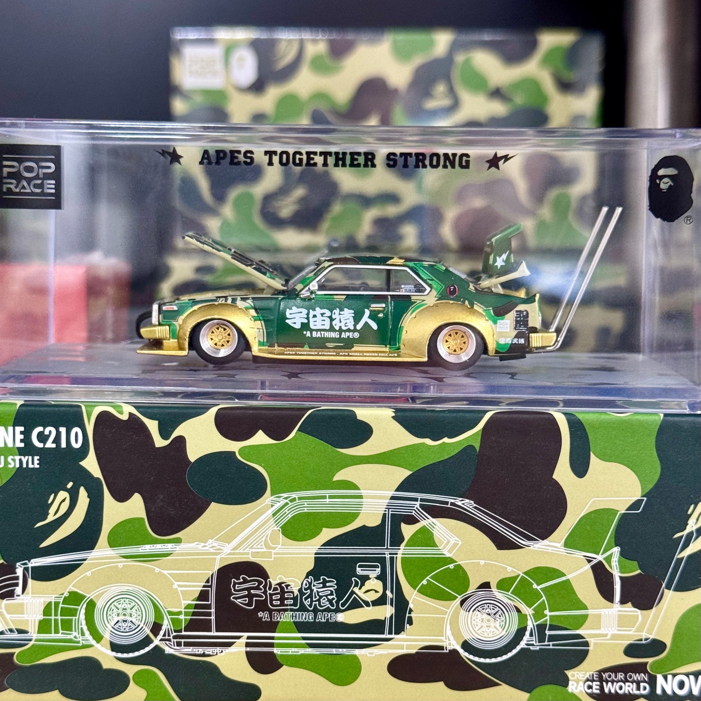 Side view of BAPE Kaido Racer Skyline diecast in clear acrylic display box