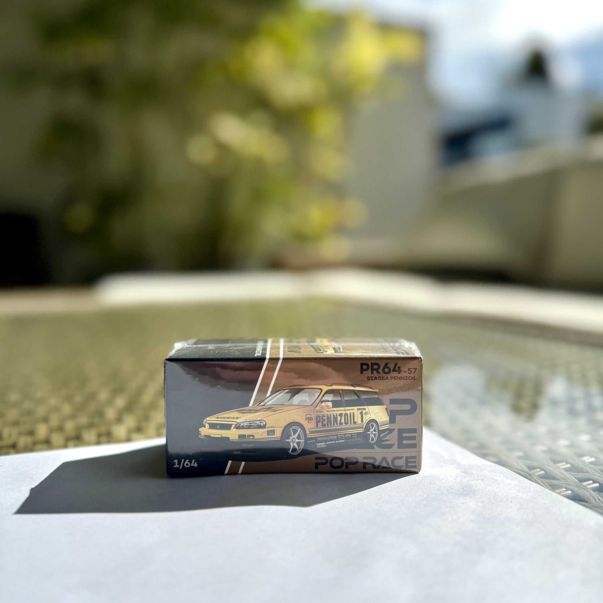 Panorama front angle of Pop Race Nissan Stagea R34 Pennzoil Gold Chrome 1:64 diecast car