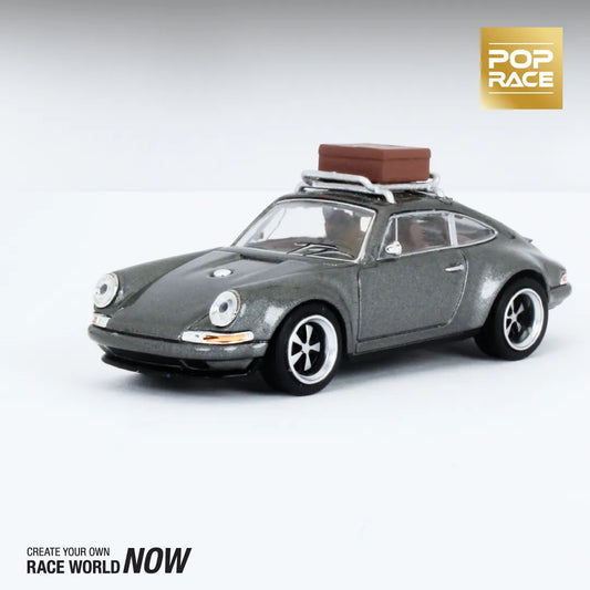 Unboxed Porsche Singer 911 diecast model with luggage on display