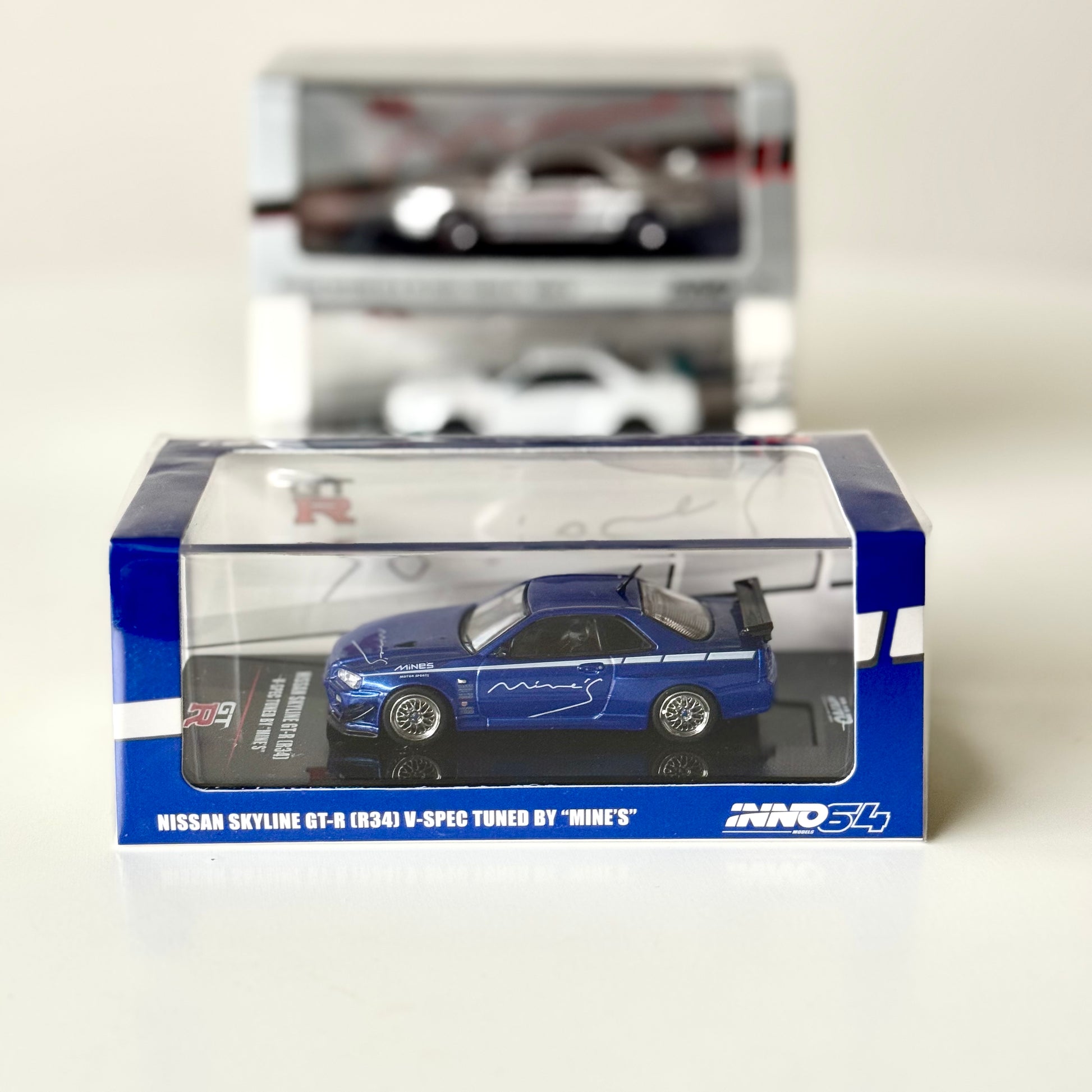 Nissan Skyline GT-R R34 V-Spec Mine’s Blue 1:64 diecast model in box – front view