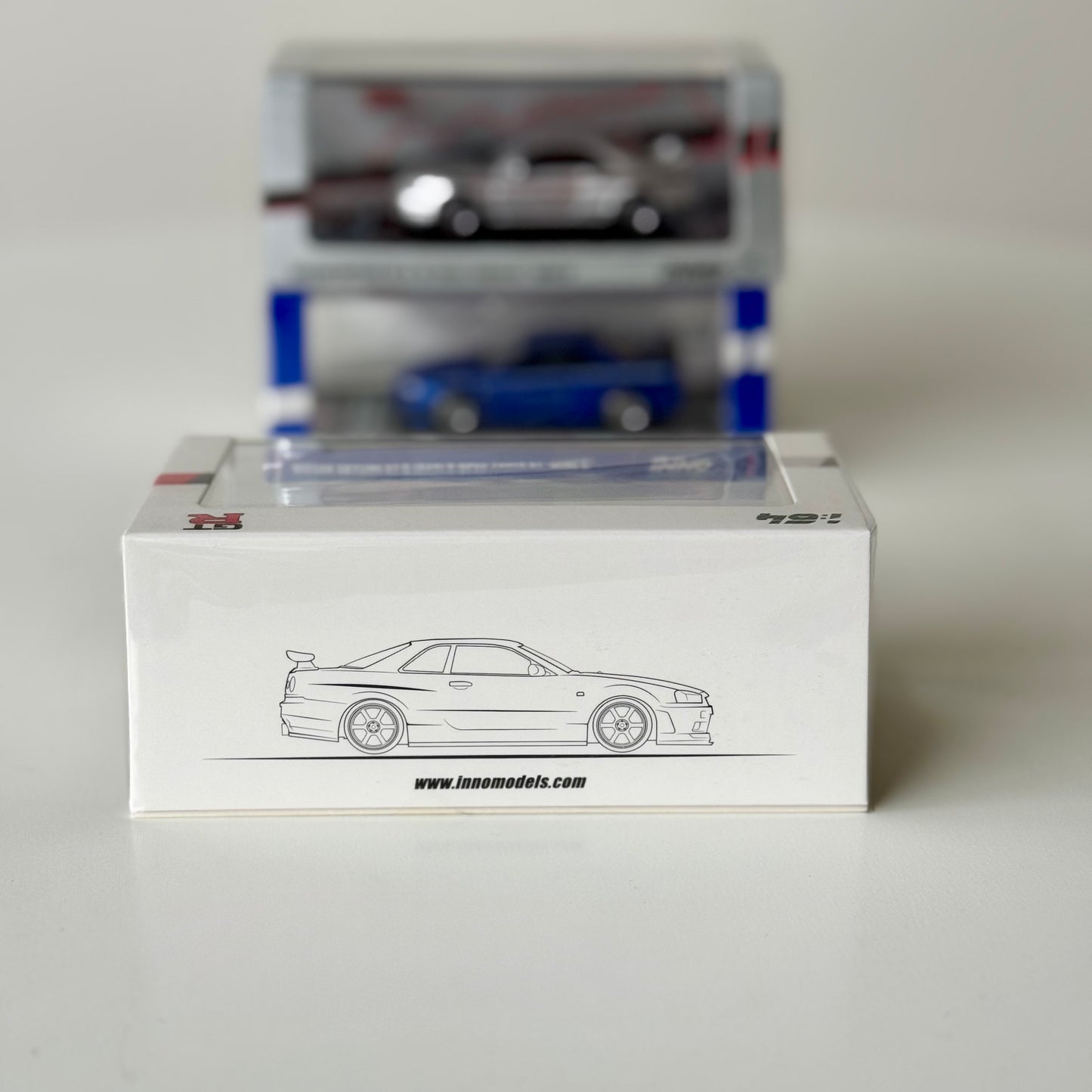 Angled view of INNO64 R34 V-Spec N1 GT-R Mine’s White in acrylic display case
