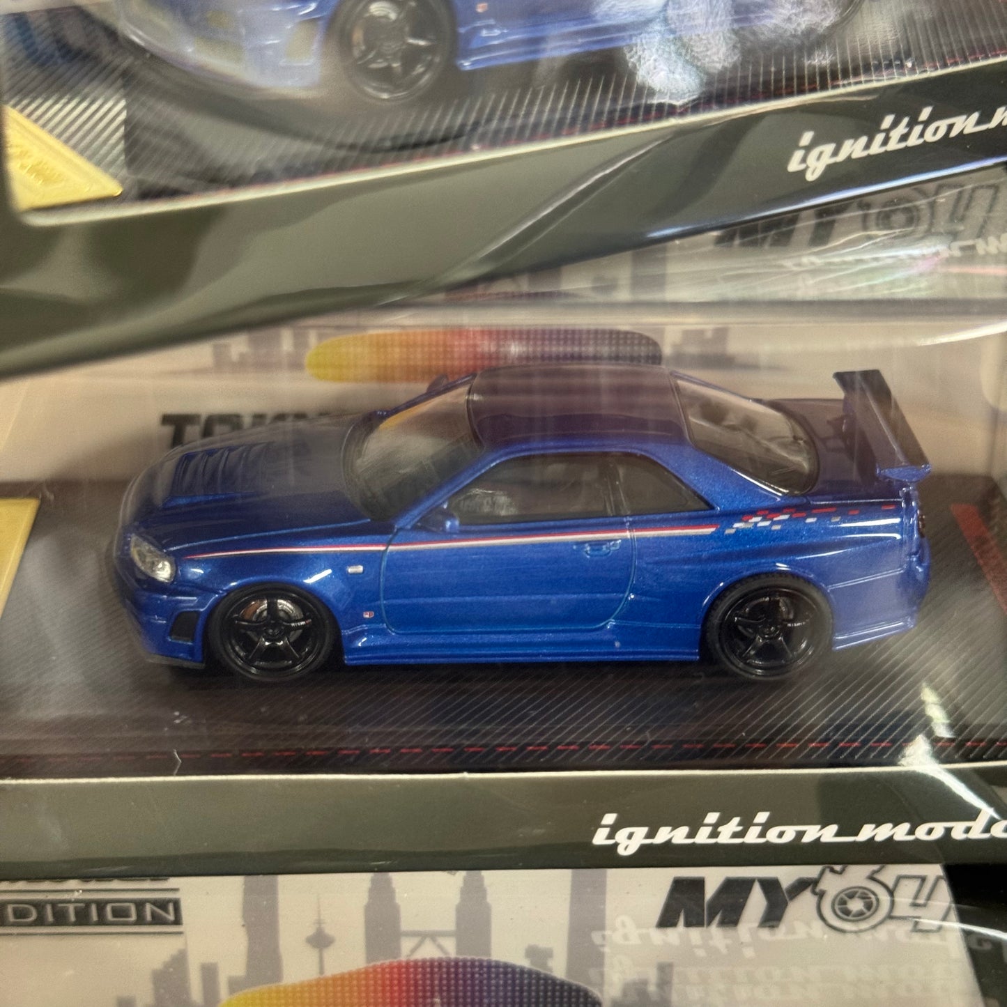 Angled boxed shot of IG3838 1:64 Nissan Skyline GT-R R34 V-Spec II resin model.
