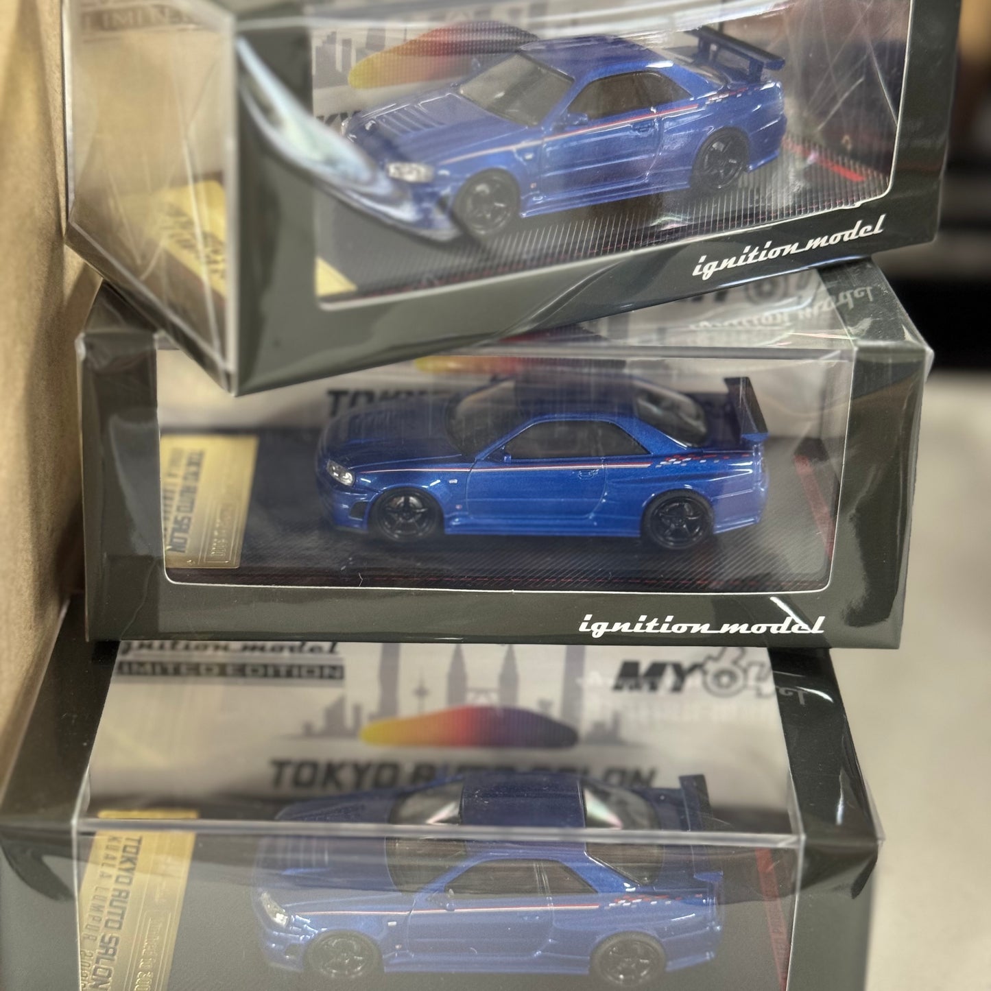 Front boxed image of IG3838 Nissan Skyline GT-R R34 V-Spec II Blue Metallic 1:64 resin model car.