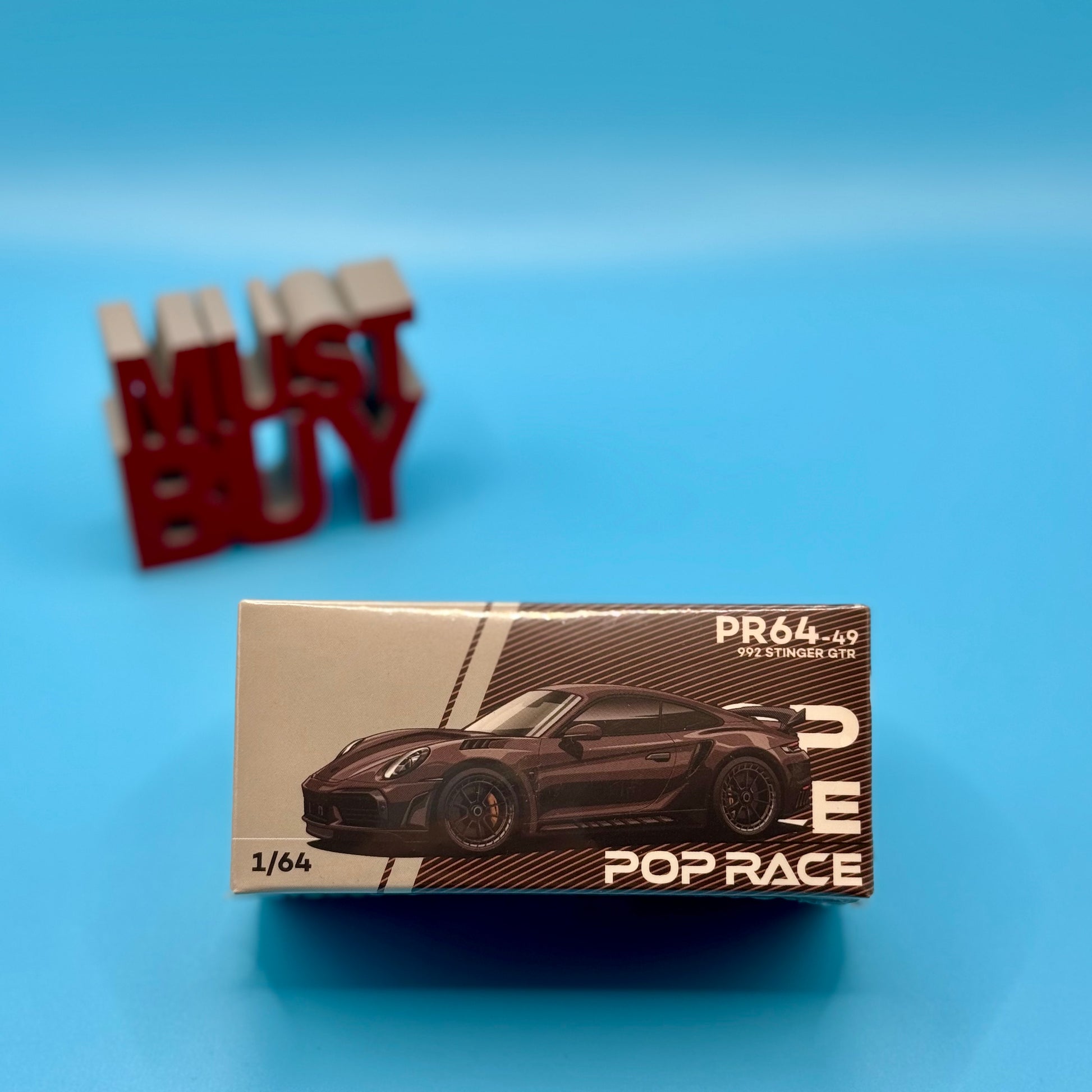 Front view of Pop Race Porsche 992 Stinger GTR Carbon Brown model in box