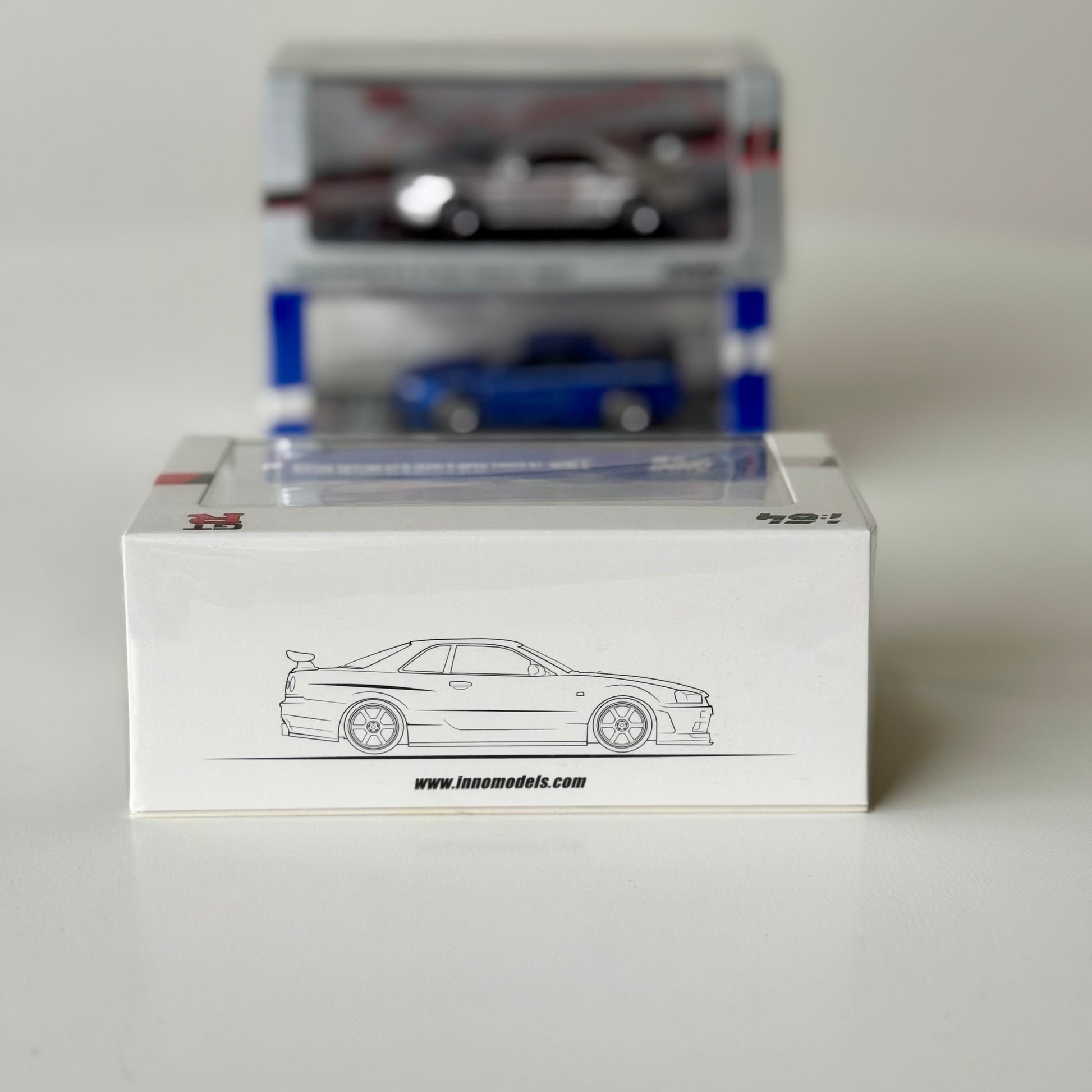 Angled view of INNO64 R34 V-Spec N1 GT-R Mine’s White in acrylic display case