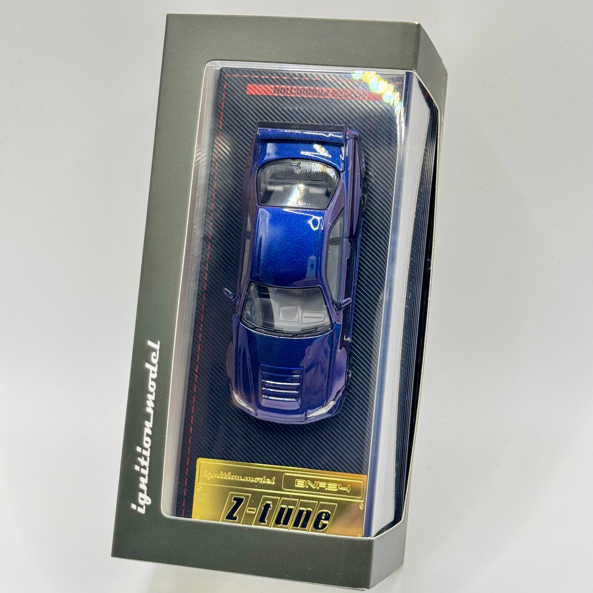 Tarmac Works x Ignition Model Nismo R34 GT-R Z-Tune 1:64 model in acrylic display packaging